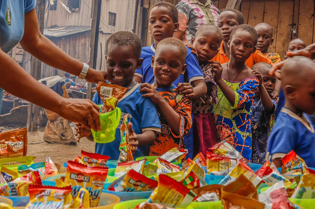 Children receive snacks from a person.