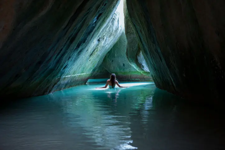 Woman swimming in a secluded grotto.